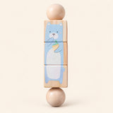 Forest Friends wooden Spin and Match toy with three connected rotating blocks and two wooden ball ends, showing one printed face on smooth pale warm beige.