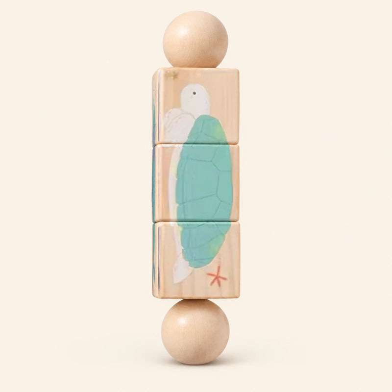 Ocean Spin wooden Spin and Match toy with three connected rotating blocks and two wooden ball ends, showing one printed face on smooth pale warm beige.