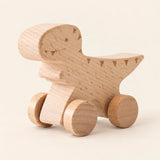 Tyrannosaurus Rex wooden rolling toy on a smooth pale warm beige background, showing its original shape and wheel design.