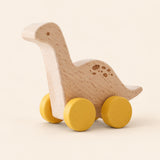 Tanystropheus wooden rolling toy on a smooth pale warm beige background, showing its original shape and wheel design.