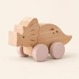 Triceratops wooden rolling toy on a smooth pale warm beige background, showing its original shape and wheel design.