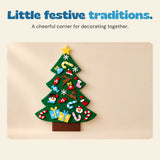 Decorated green felt Christmas tree hanging on a beige wall in a quiet home corner.