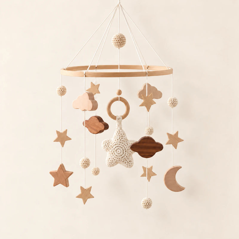 White hanging mobile with its source-matched wooden support, cords and individual charms on warm beige.