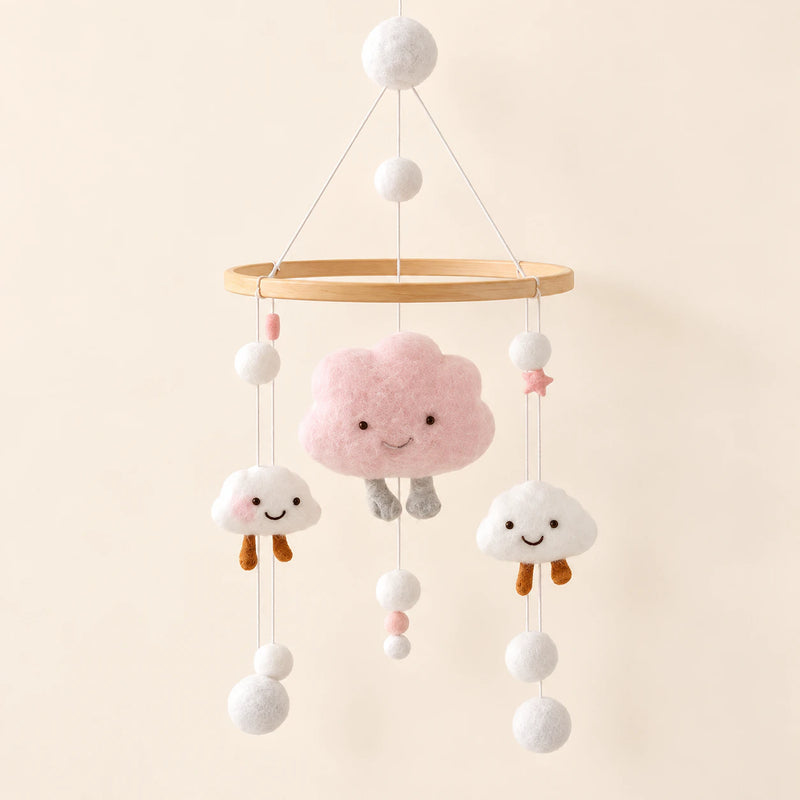 Pink Cloud Plush hanging mobile with its source-matched wooden support, cords and individual charms on warm beige.