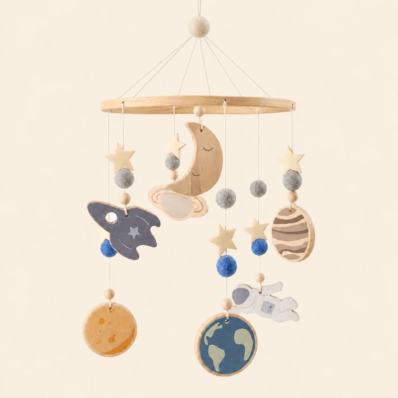 Space hanging mobile with its source-matched wooden support, cords and individual charms on warm beige.