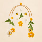 Yellow Honey Bee hanging mobile with its source-matched wooden support, cords and individual charms on warm beige.