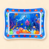 Blue ocean tummy time mat with a transparent water-filled centre and colourful floating shapes on beige.