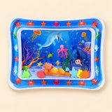 Blue ocean tummy time mat with a transparent water-filled centre and colourful floating shapes on beige.