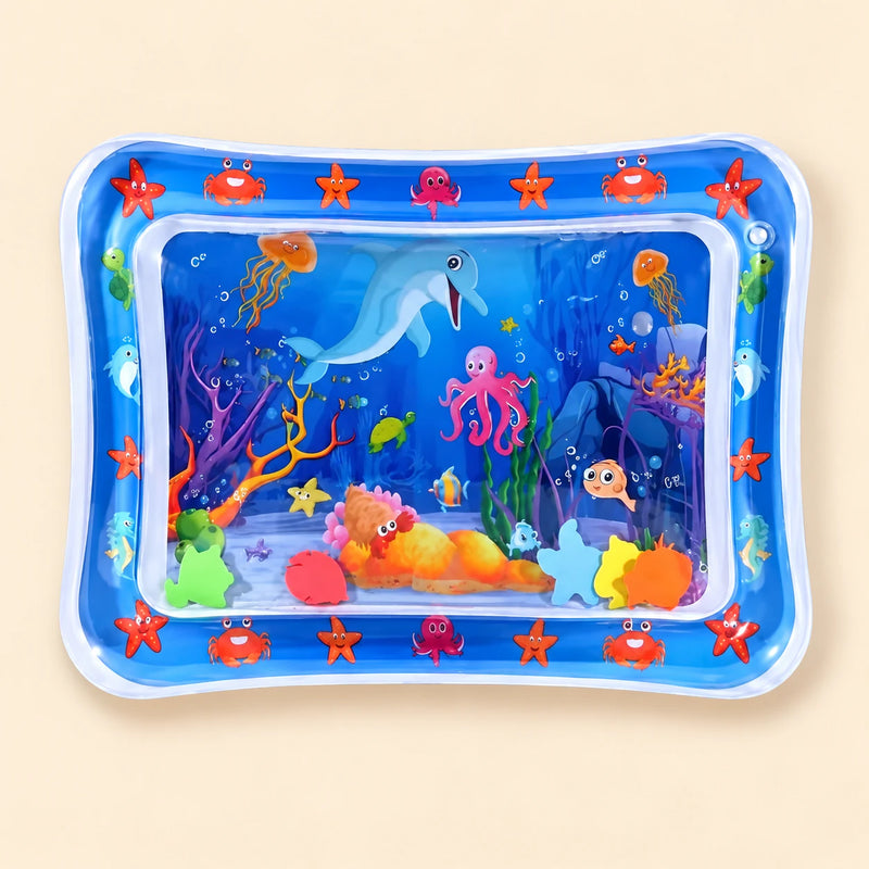 Blue ocean tummy time mat with a transparent water-filled centre and colourful floating shapes on beige.