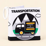 Transportation soft cloth book with its printed front cover and white fabric loop on warm beige.