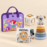 Mermaid Purple Plus busy board with an off-white and yellow activity cube, ANIMAL lion cloth book and six-ring koala stacking tower on a calm beige background.