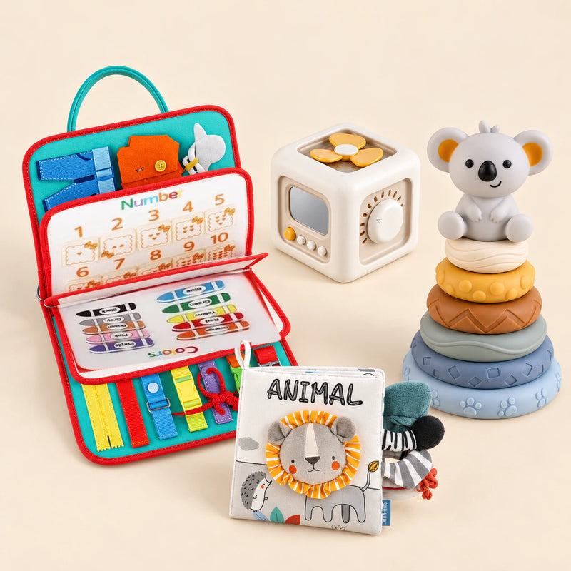 Rocket Green Plus busy board with an off-white and yellow activity cube, ANIMAL lion cloth book and six-ring koala stacking tower on a calm beige background.