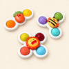 Carrot, bee and lion texture spinners with colourful moulded buttons on a pale beige background.