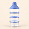 Blue powder dispenser tower with four clear stacked compartments and a capped funnel top, alone on warm beige.