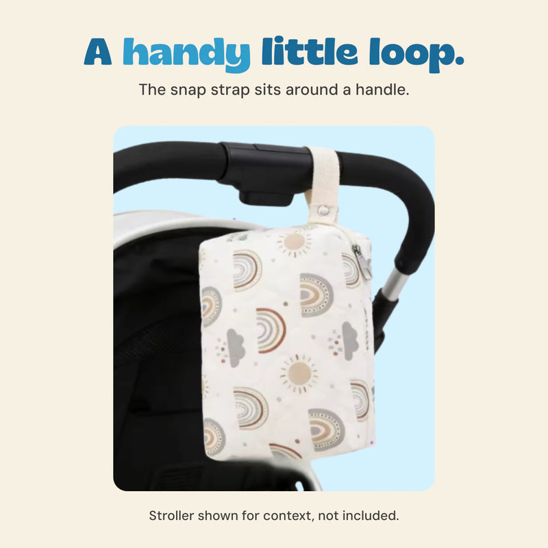 Original rainbow-print quilted pouch hanging vertically from a black stroller handle by its snap strap.