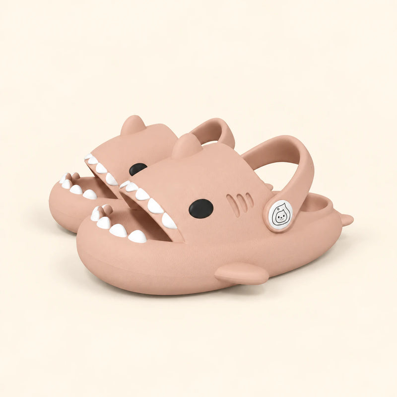 A matching pair of shark slides in the Pink Cloud Plush colour on a warm beige background.