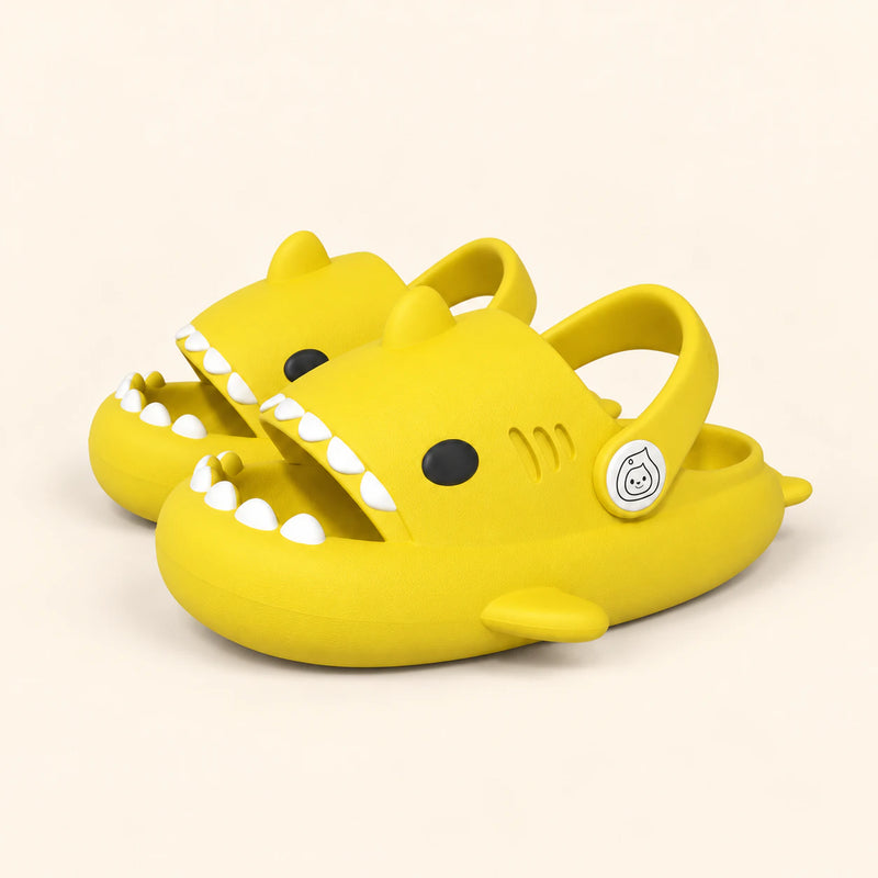 A matching pair of shark slides in the Yellow Honey Bee colour on a warm beige background.