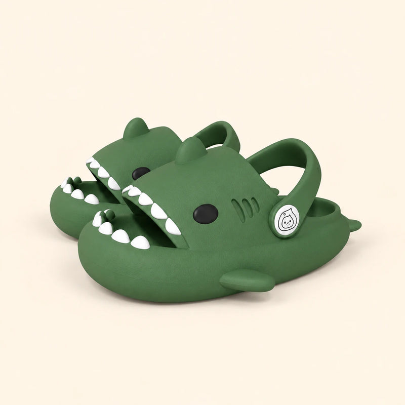 A matching pair of shark slides in the Dark Green colour on a warm beige background.