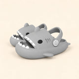 A matching pair of shark slides in the Grey colour on a warm beige background.
