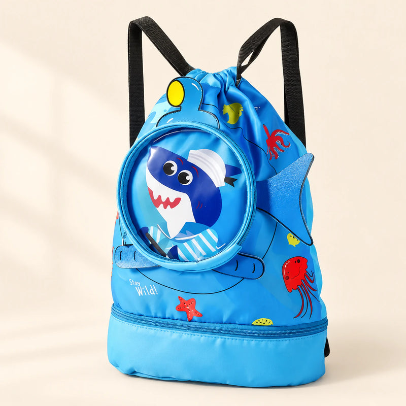 Big blue shark-print drawstring backpack with black straps, round clear front pocket and side fin, with a zipped base compartment.