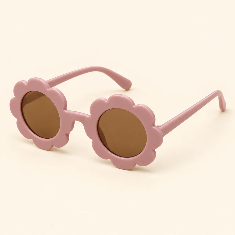 One pair of flower-shaped sunglasses with round brown lenses in the Baby pink colour on a warm beige background.