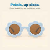 Front view of pale blue sunglasses with petal-shaped rims and brown round lenses.