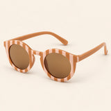 Peach Checker Sun Shades with the original frame pattern, open arms and brown lenses on warm beige.