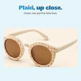A closer view of the Cream option with its fine tan and grey plaid frame and warm brown lenses.