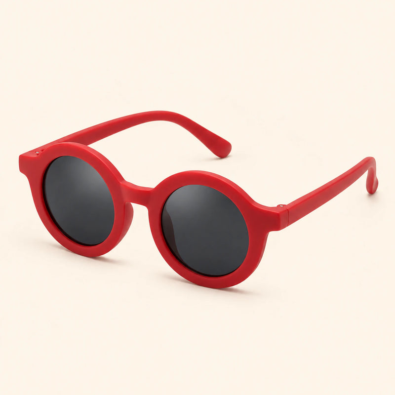One pair of round sunglasses in the Cherry Red option on a warm beige background.