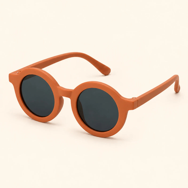 One pair of round sunglasses in the Burnt Orange option on a warm beige background.