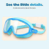 Closer view of the blue and aqua goggles, their broad clear lens, ridged strap and white rear clip.