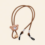 Brown cord with bear charm, sliding bead and two adjustable black end loops on a warm beige background.