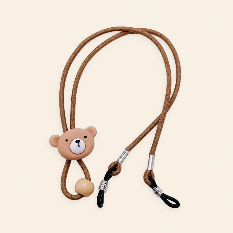 Brown cord with bear charm, sliding bead and two adjustable black end loops on a warm beige background.
