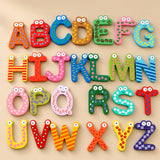 Colourful wooden alphabet letters with painted patterns and smiling faces arranged on a warm beige studio surface.