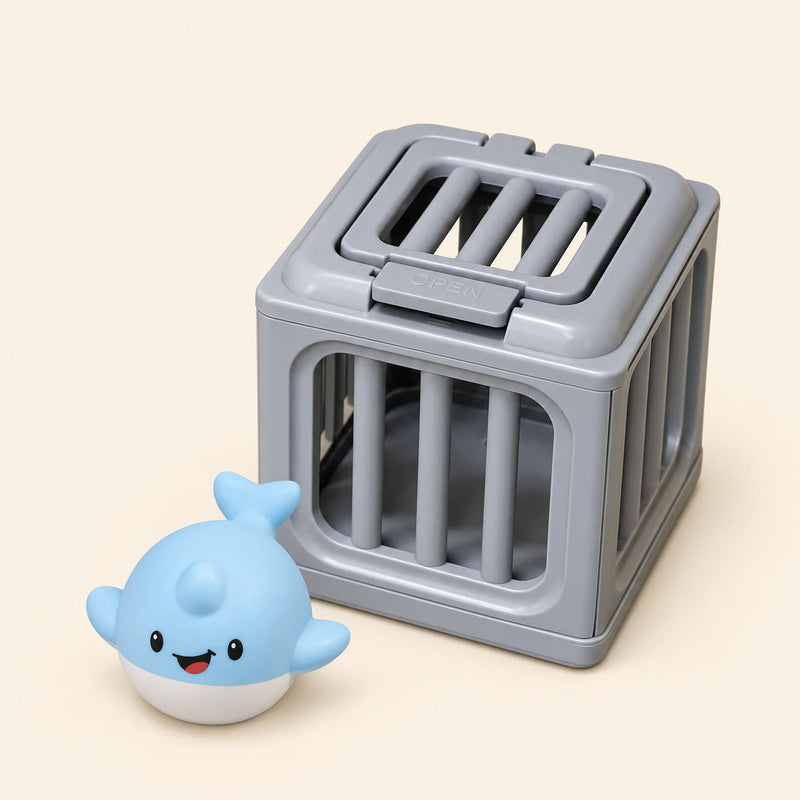One pale blue dolphin with a white belly and smiling face toy beside one gray rescue cage on a warm beige background. This is one separate variant choice.