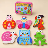 A storage tin and six assembled puzzles showing ladybird, butterfly, toucan, snail, owl and frog on a sunlit beige table.