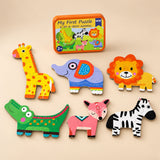 A storage tin and six assembled puzzles showing giraffe, elephant, lion, crocodile, deer and zebra on a sunlit beige table.