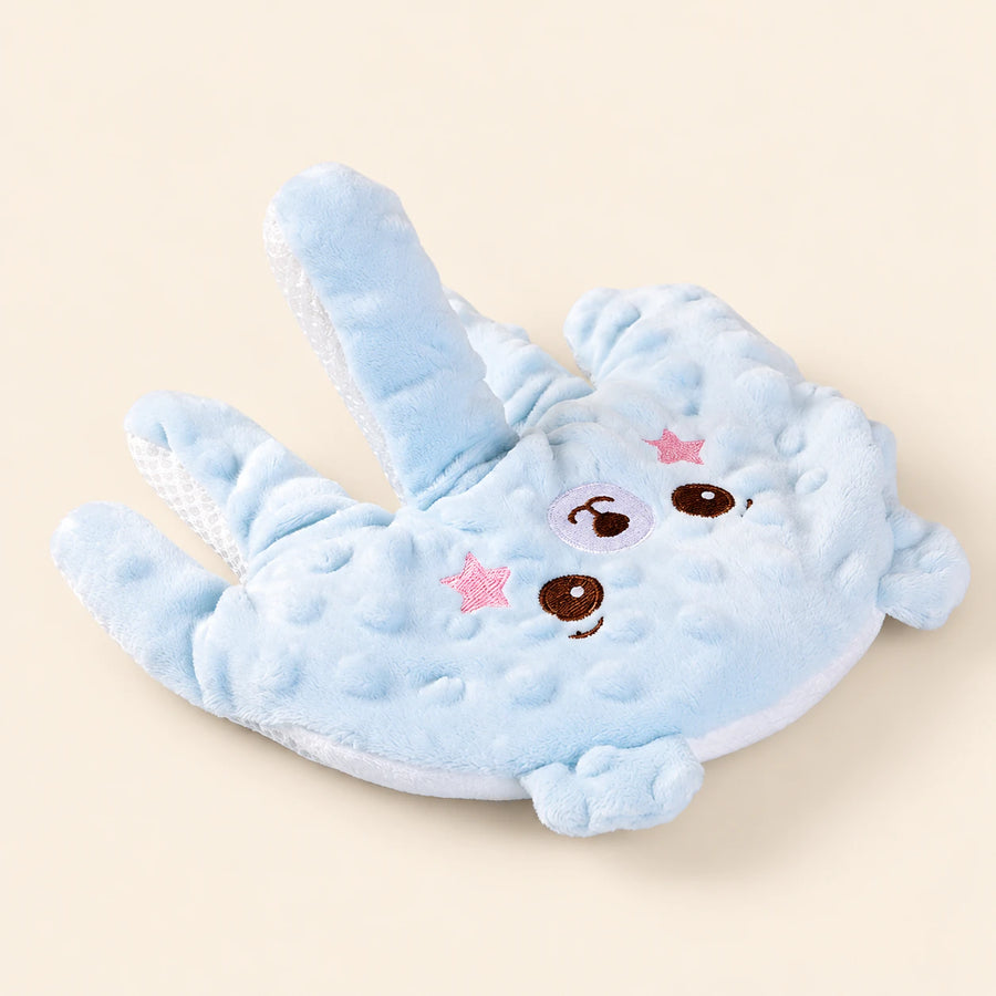 Sky hand-shaped plush pillow with its original embroidered character face and raised-dot fabric, alone on warm beige.