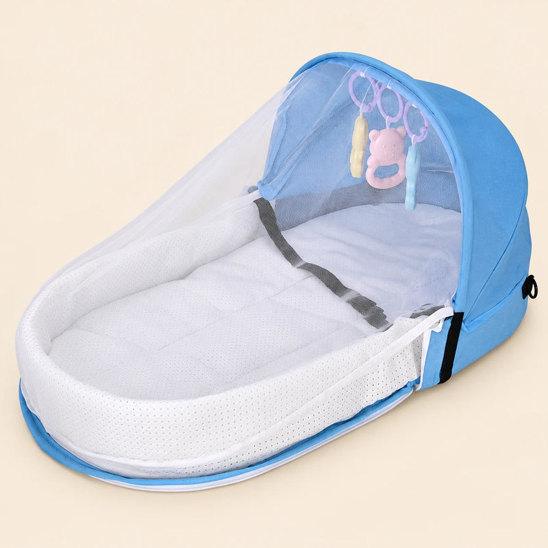 Open sky blue tent with a white mesh canopy, padded oval interior and three hanging animal toys on warm beige.