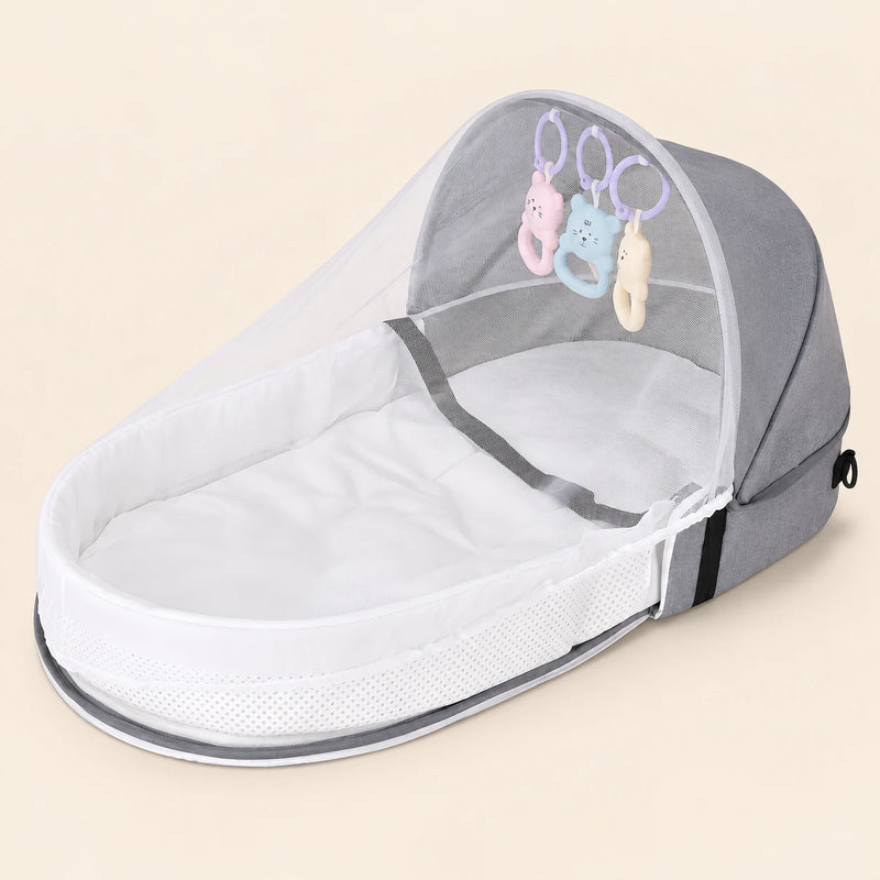 Open soft grey tent with a white mesh canopy, padded oval interior and three hanging animal toys on warm beige.