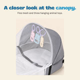 Close view of the grey canopy, fine white mesh and three pastel hanging animal ring toys.