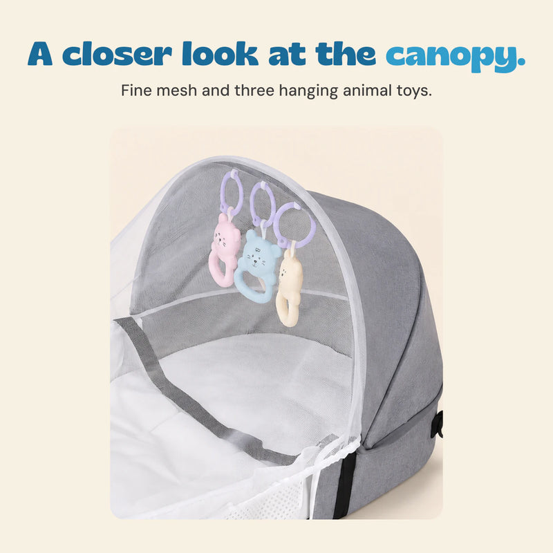 Close view of the grey canopy, fine white mesh and three pastel hanging animal ring toys.