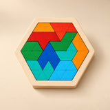 A hexagonal wooden puzzle filled with red, orange, green and blue triangular pieces in warm daylight.