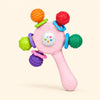 Blush Pink Rattle with five colourful textured ends and a long handle, alone on warm beige.