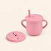 Blush Pink silicone cup with two side handles, fitted straw lid and straw, plus a separate snack lid on warm beige.