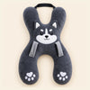 Charcoal Husky travel pillow with its original face, wraparound shape, front loops and upper strap on warm beige.