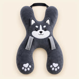 Charcoal Husky travel pillow with its original face, wraparound shape, front loops and upper strap on warm beige.