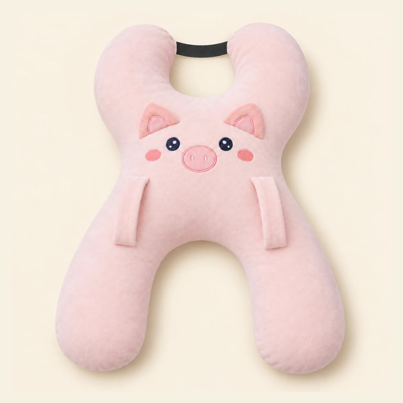 Blush Pig travel pillow with its original face, wraparound shape, front loops and upper strap on warm beige.