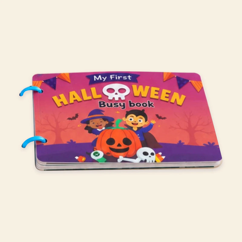 Original pink and orange Halloween Busy Book cover with pumpkins, friendly characters and two blue binding rings on warm beige.