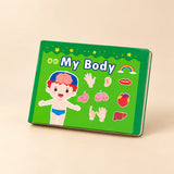 Hands holding the green My Body quiet book, showing its illustrated cover.